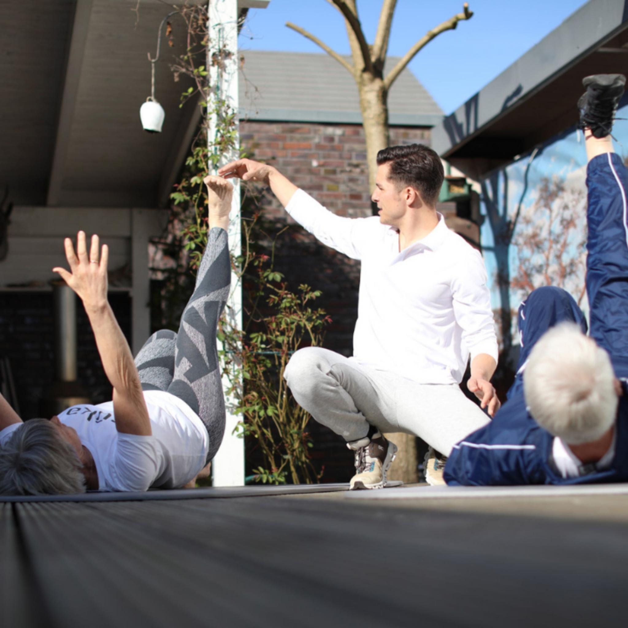 der Physiotherapeut Michel Menzel macht Päventionsübungen mit einem Paar und korrigiert